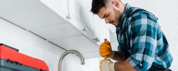 selective-focus-of-repairman-holding-plunger-in-ki-resize.jpg